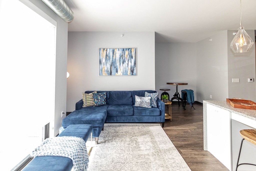 a living room with a blue couch and a kitchen at Soll, Iowa, 50312