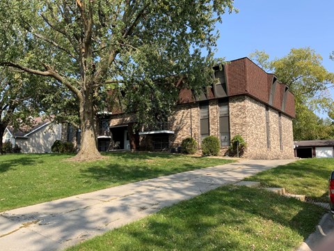 A house with a tree in front of it.