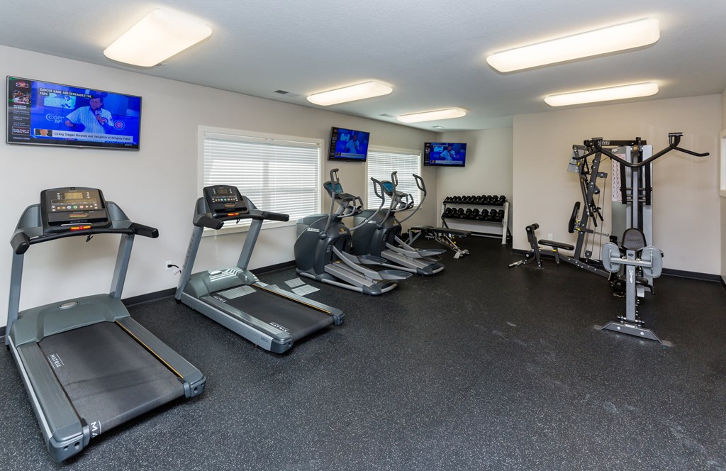 A gym with treadmills, elliptical machines, and exercise bikes.