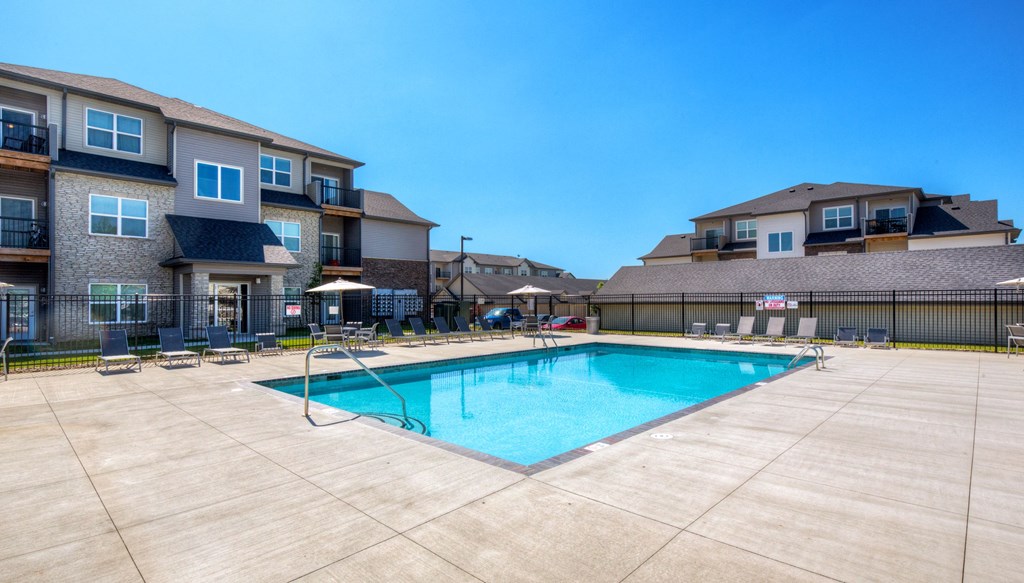 our apartments offer a swimming pool with a building in the background at Stonegate Crossing Apartments, Clive