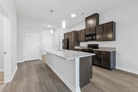 A modern kitchen with dark brown cabinets and a white island.