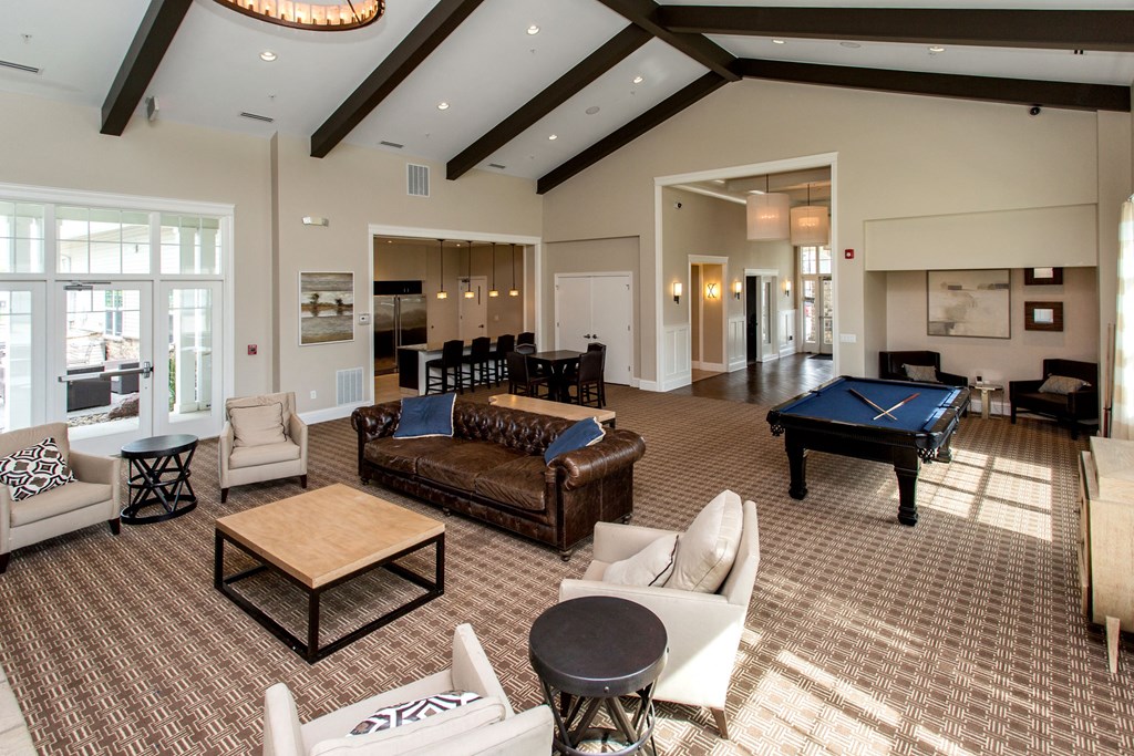 a large living room with a pool table and couches at The Winhall of Williams Pointe Apartments, Waukee, IA, 50263