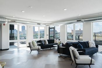 A living room with a black couch and a chair.at Level, Des Moines  