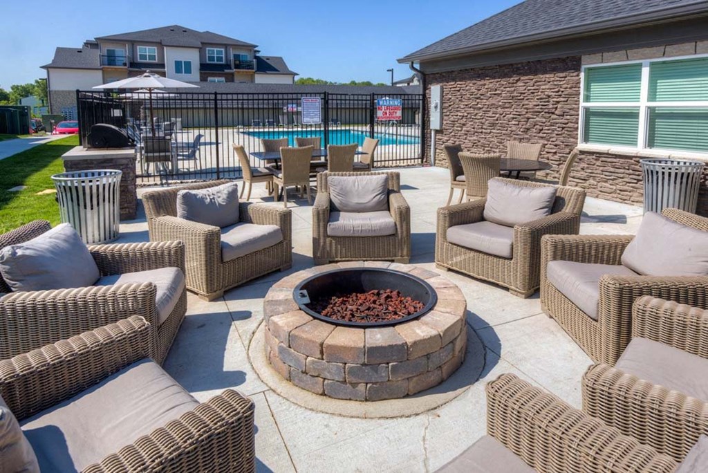 A patio with a fire pit and chairs. at Stonegate Crossing Apartments, Clive