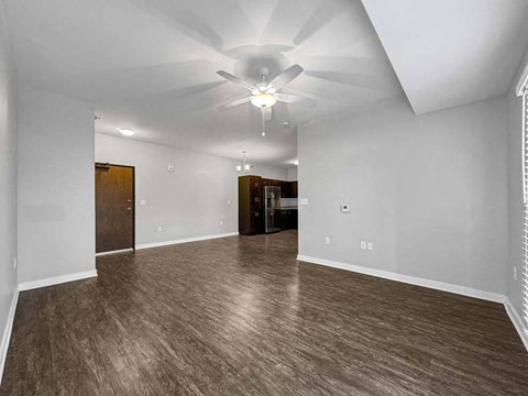 A spacious room with wood flooring and a ceiling fan. at Stonegate Crossing Apartments, Clive, 50325