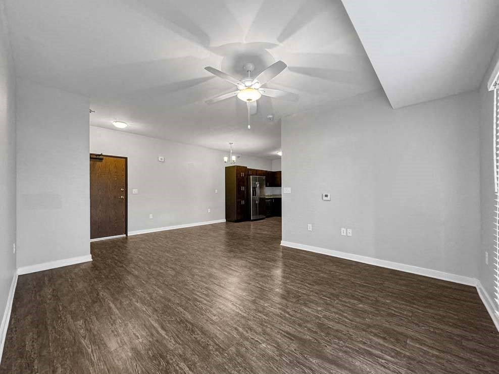 A spacious room with wood flooring and a ceiling fan. A spacious room with wood flooring and a ceiling fan. at Stonegate Crossing Apartments, Clive, 50325