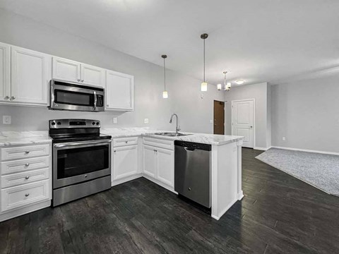 A kitchen with white cabinets and a black stove top oven.