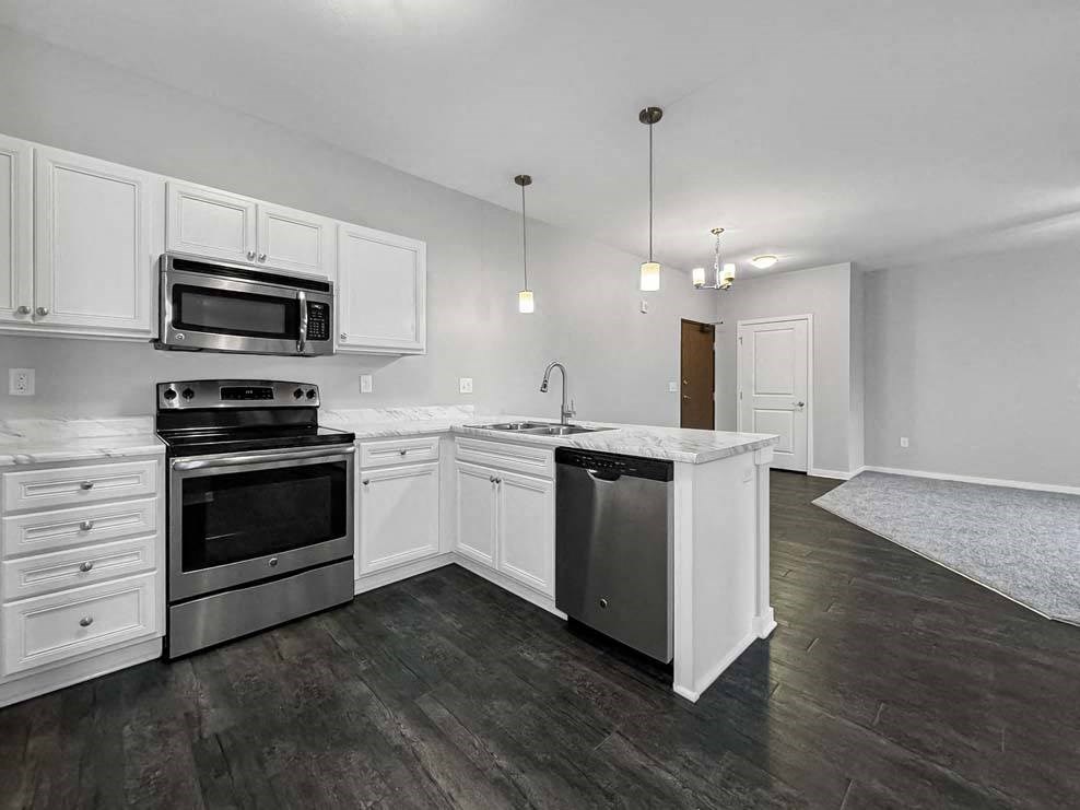 an empty kitchen with white cabinets and stainless steel appliances an empty kitchen with white cabinets and stainless steel appliances at Stonegate Crossing Apartments, IOWA, 50325