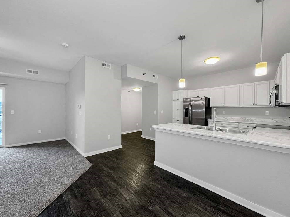 A kitchen with white cabinets and a stainless steel refrigerator at Stonegate Crossing Apartments, Clive, IOWA