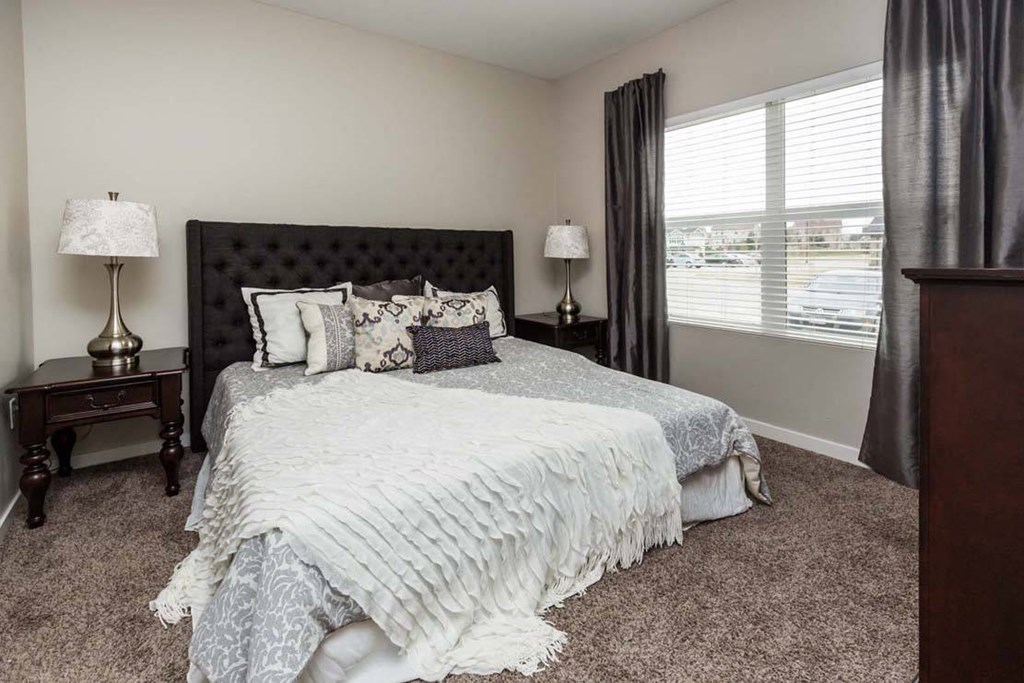 a bedroom with a bed and a window a bedroom with a bed and a window at Stonegate Crossing Apartments, IOWA, 50325