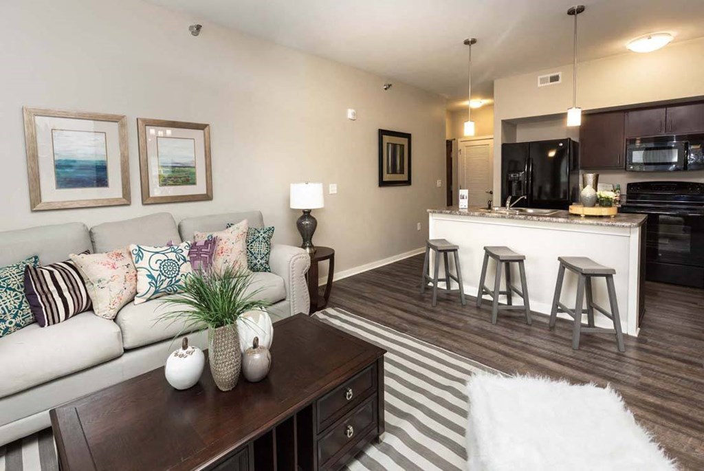 a living room and kitchen with a couch and a table at Stonegate Crossing Apartments, Clive, IA