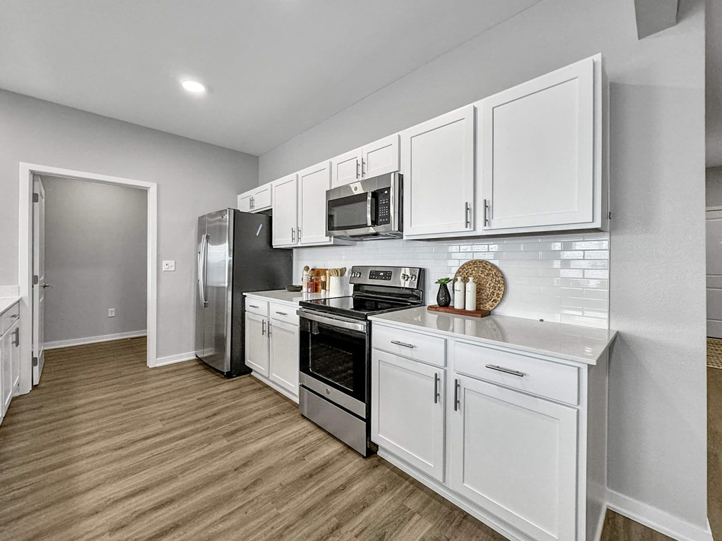 a kitchen with white cabinets and stainless steel appliances at Rialto Townhomes Apartments, Waukee, Iowa