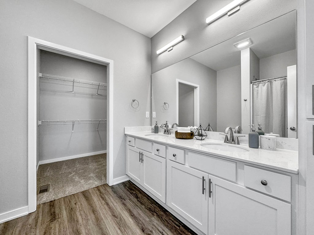 a bathroom with a large mirror and two sinks at Rialto Townhomes Apartments, Waukee, 50263