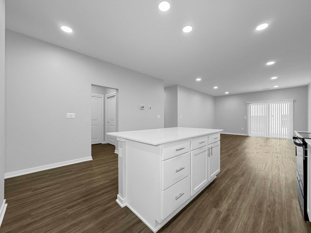 a white kitchen with a large island in the middle of it at Rialto Townhomes Apartments, Iowa