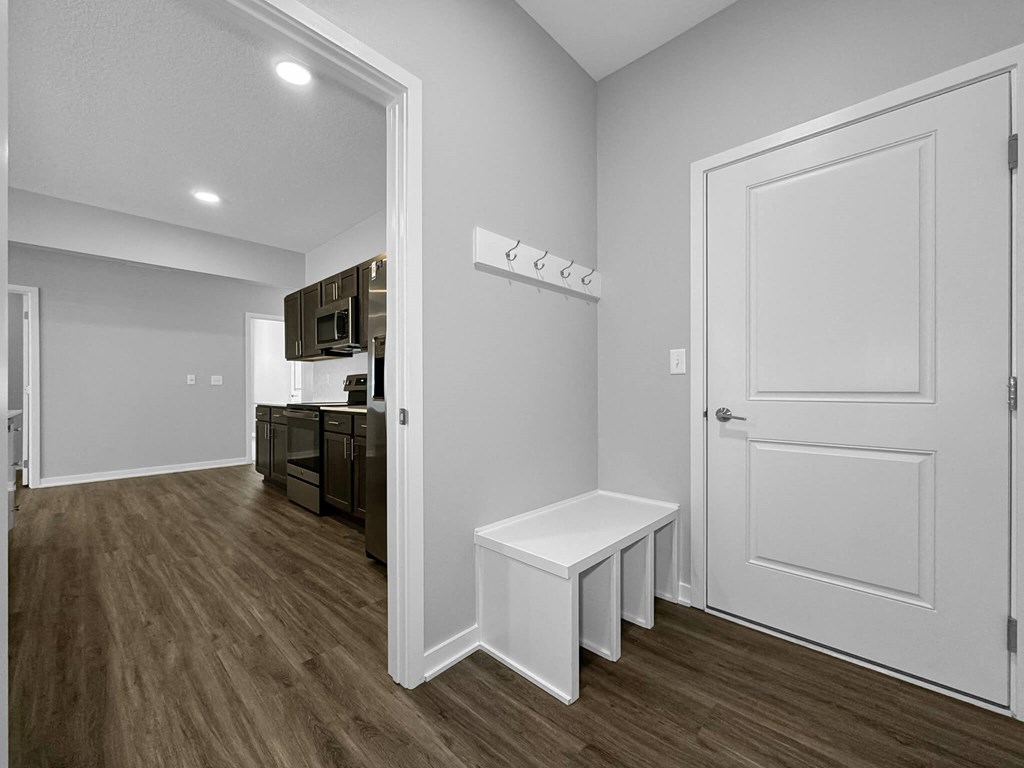 a door opens into a kitchen and living room with wood flooring at Rialto Townhomes Apartments, Waukee, IA, 50263