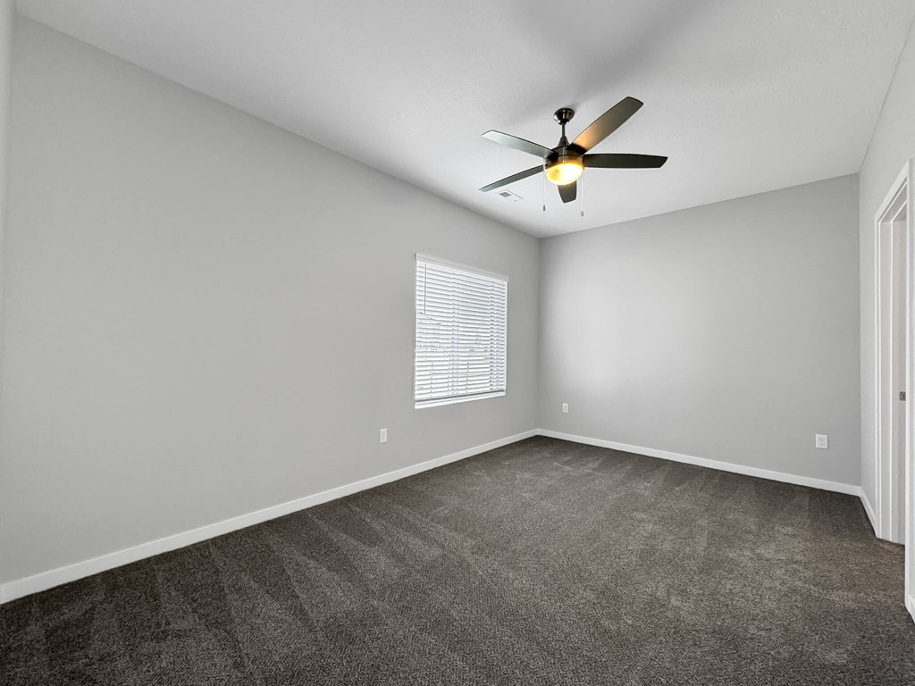 an empty living room with a ceiling fan and a window at Rialto Townhomes Apartments, Waukee, 50263