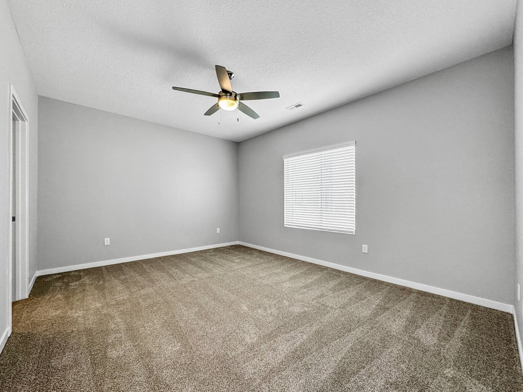 an empty living room with a ceiling fan and a window at Rialto Townhomes Apartments, Waukee, IA, 50263