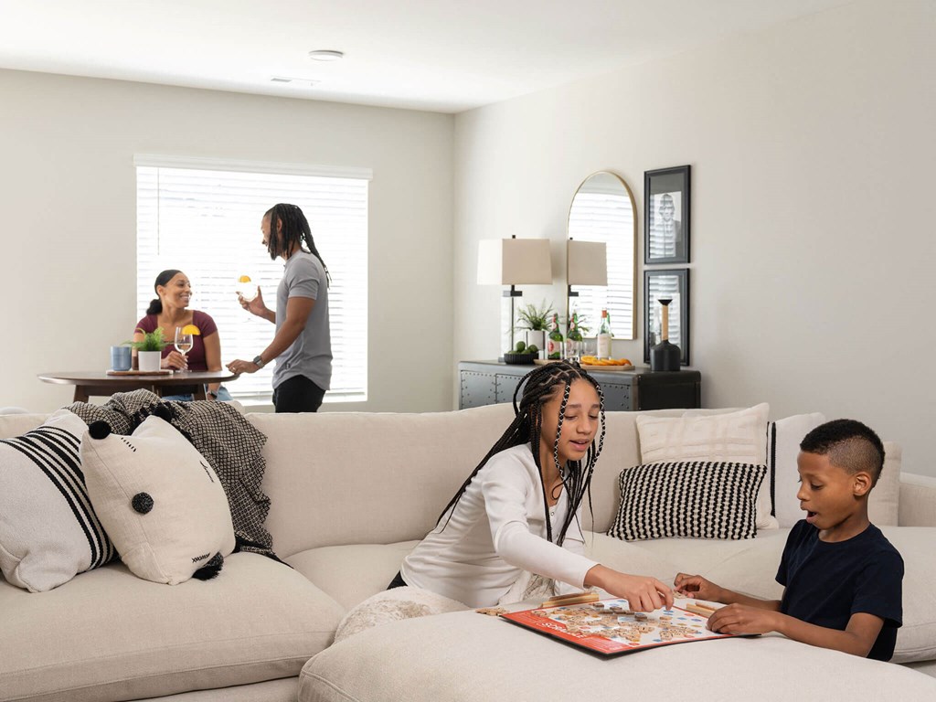 a woman sitting on a couch with a child reading a book at Rialto Townhomes Apartments, Iowa