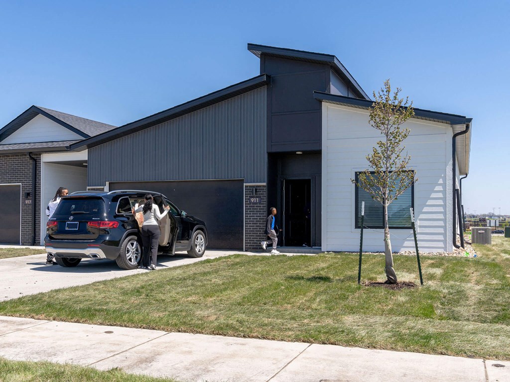 a car is parked in front of a building at Rialto Townhomes Apartments, Waukee, Iowa