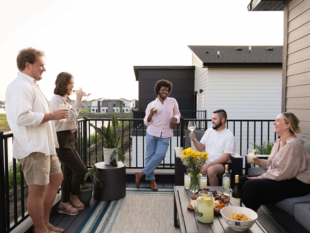 a group of people standing on a balcony with drinks at Rialto Townhomes Apartments, Iowa, 50263