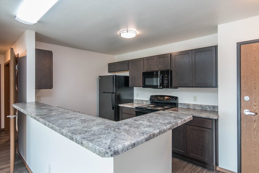 a kitchen with black appliances and a granite counter top at Penbrooke Place Apartments, Sioux Falls