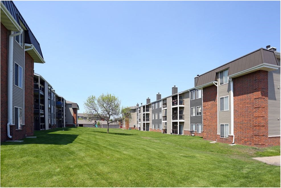 an exterior view of an apartment complex with green grass at Penbrooke Place Apartments, Sioux Falls, SD, 57106
