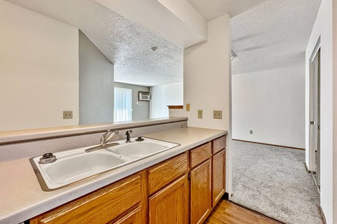 A kitchen with wooden cabinets and a white sink.
