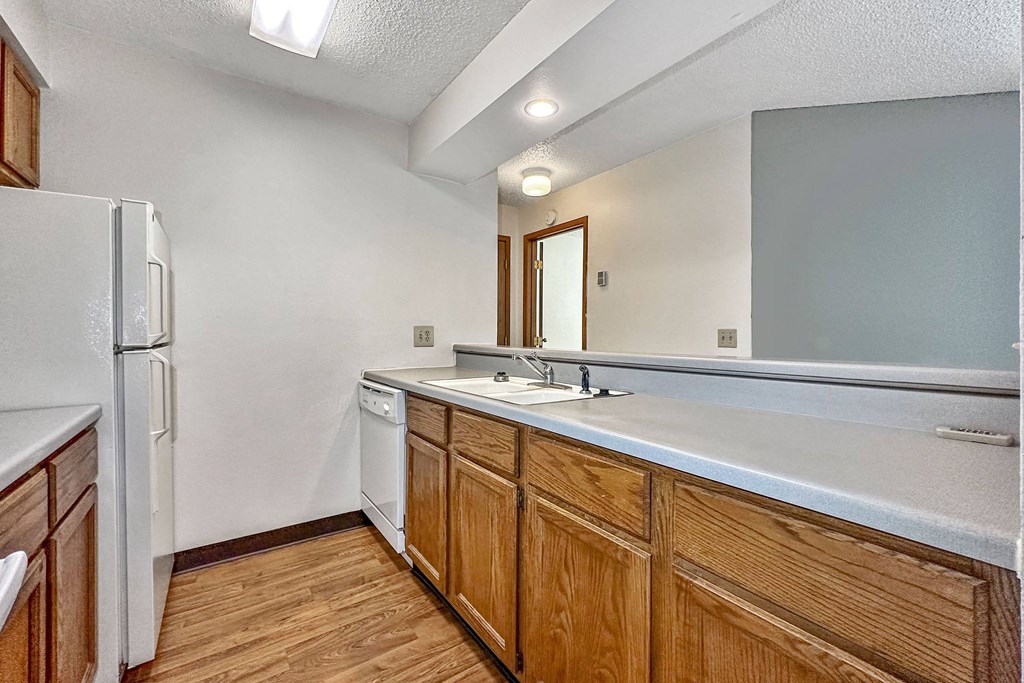 A kitchen with wooden cabinets and a white fridge at Penbrooke Place Apartments, Sioux Falls, SD, 57106