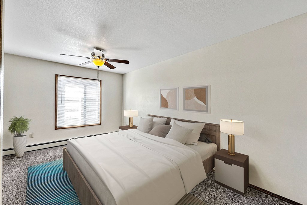 A bedroom with a bed, two lamps, a ceiling fan, and a potted plant A bedroom with a bed, two lamps, a ceiling fan, and a potted plant at Penbrooke Place Apartments, South Dakota, 57106