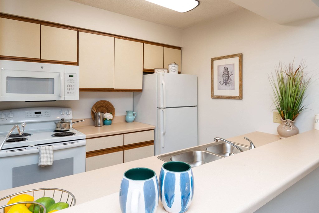 A kitchen with a white countertop and a white refrigerator at Penbrooke Place Apartments, Sioux Falls