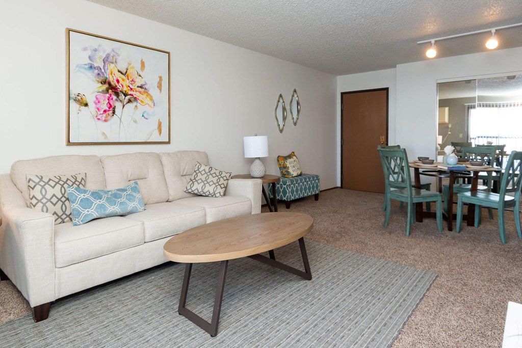 A living room with a white couch and a wooden coffee table at Penbrooke Place Apartments, Sioux Falls, South Dakota