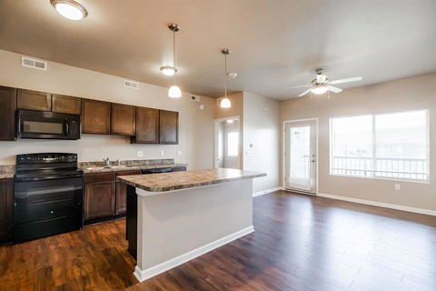 A kitchen with a black stove top oven and a black microwave.