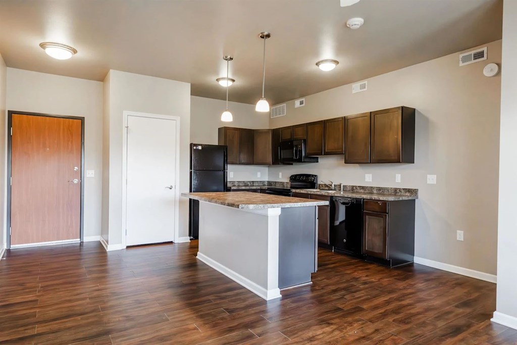 A kitchen with a wooden floor and a white island.