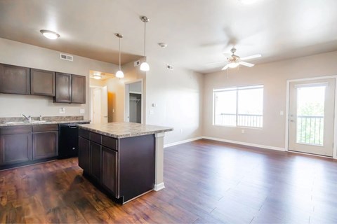 A kitchen with dark wood cabinets and a light colored floor.