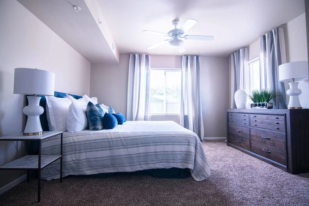 A bedroom with a bed, nightstand, and dresser.