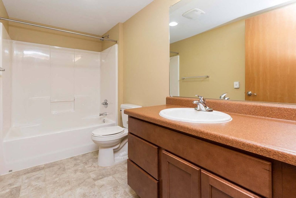 A bathroom with a toilet, sink, and shower.at Riverpoint Lofts, Des Moines Iowa