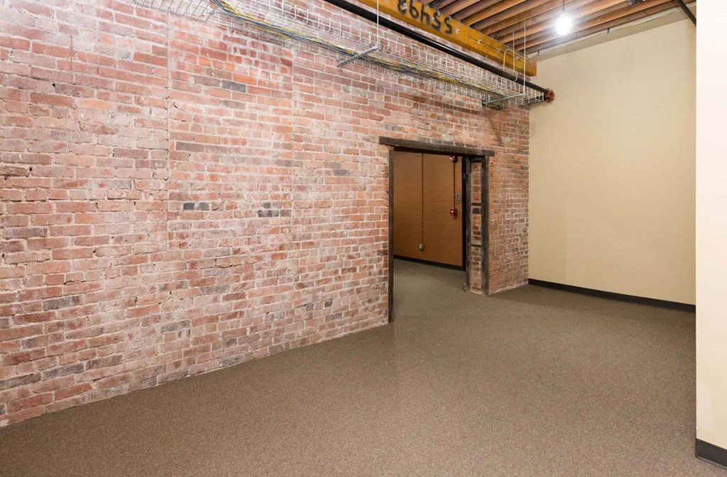 A room with a brick wall and a door.at Riverpoint Lofts, Des Moines  