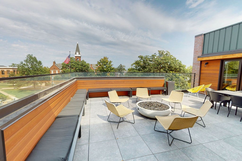 a rooftop terrace with chairs and tables and a fire pit at Canary Lofts, Des Moines, 50311