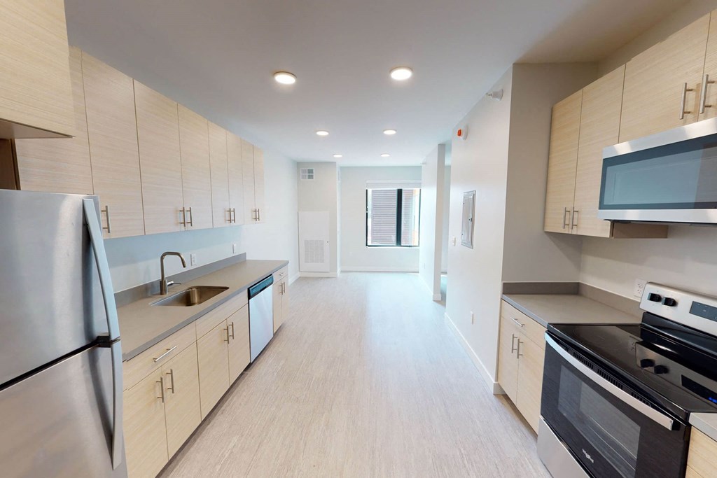 a kitchen with white cabinets and stainless steel appliances at Canary Lofts, Iowa, 50311