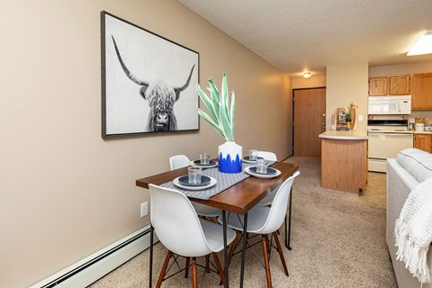 our apartments offer a dining room table with chairs and a view of the kitchen at Lake Shore Park, Iowa