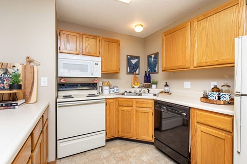 A kitchen with wooden cabinets and white appliances.