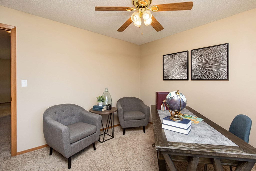 A room with a table, two chairs, and a ceiling fan at Lake Shore Park, Ankeny