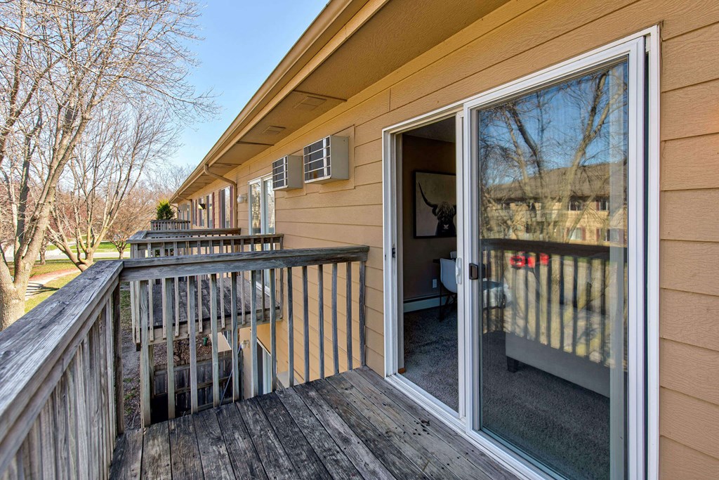 a porch with a sliding glass door and a deck at Lake Shore Park, Ankeny, IA