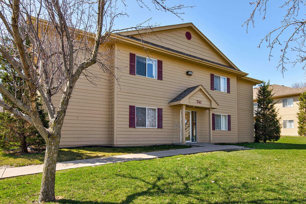 A beige house with a tree in front at Lake Shore Park, Ankeny, IA 50021