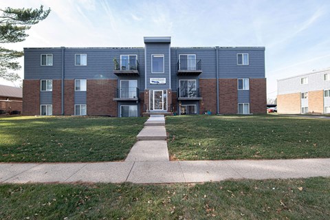 A large apartment complex with a grassy front yard at Lake Shore Place Apartments, Ankeny, IA,  50021