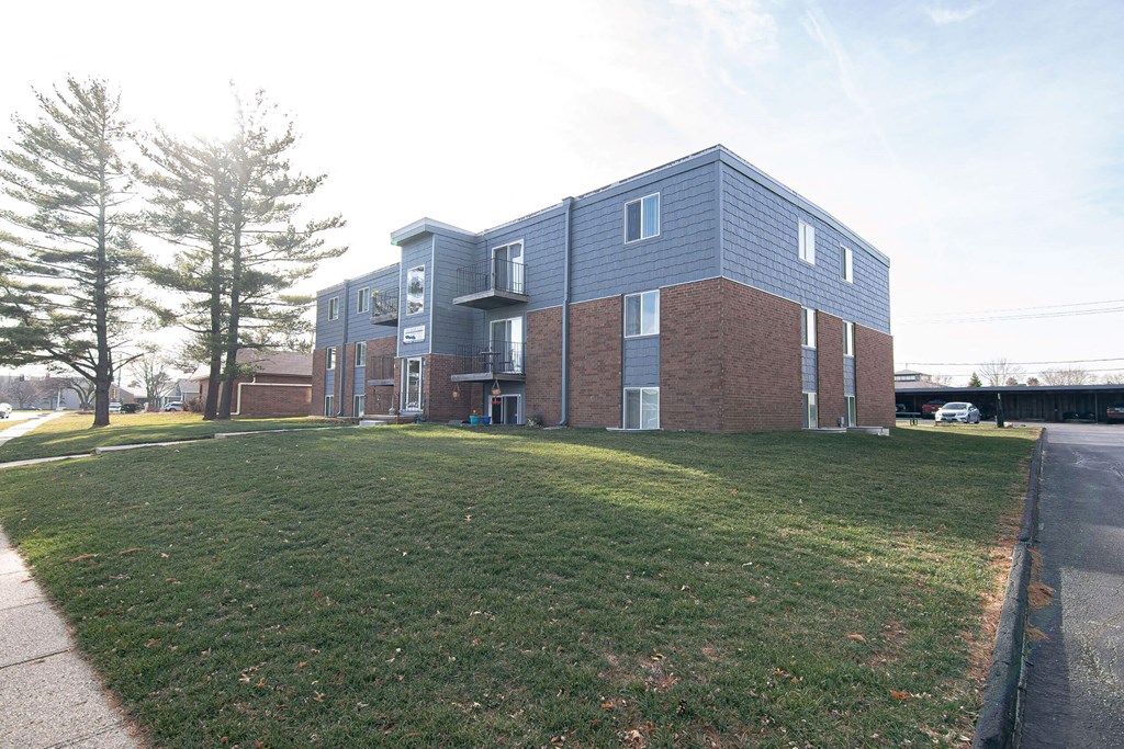 A large building with a green lawn in front at Lake Shore Place Apartments, Ankeny, IA