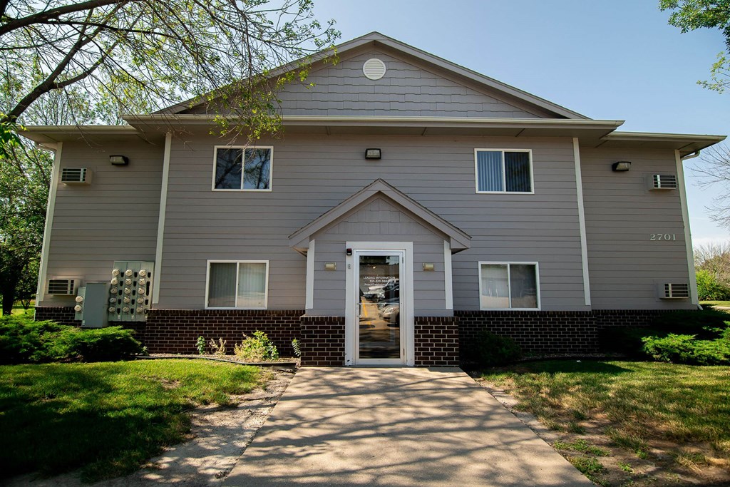 a white house with a sidewalk in front of it at Peach Tree Apartments, Ankeny