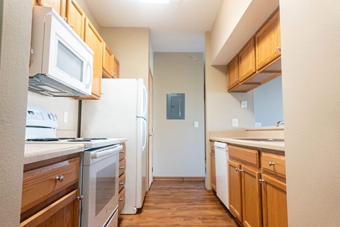 A kitchen with wooden cabinets and white appliances.