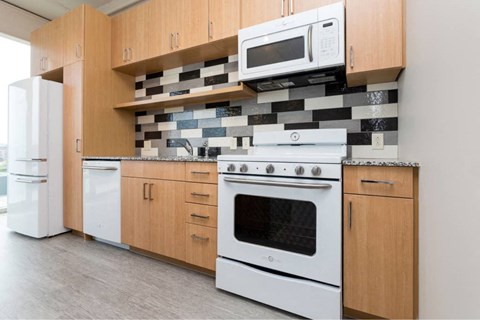 A kitchen with white appliances and wooden cabinets. A kitchen with white appliances and wooden cabinets.at City Square Lofts, Des Moines, 50309