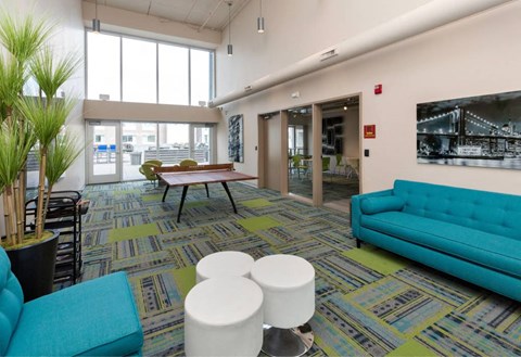 A room with a blue couch and a green plant.at City Square Lofts, Des Moines, IA  